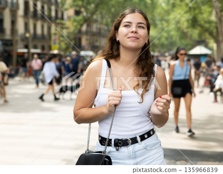 Happy young female tourist strolling along La Rambla in Barcelona 135966839