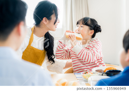 Family of four eating in the dining room Family of four eating in the dining room 135966949