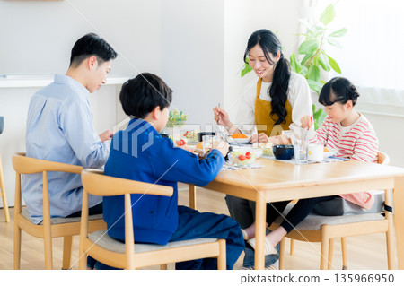 Family of four eating in the dining room Family of four eating in the dining room 135966950