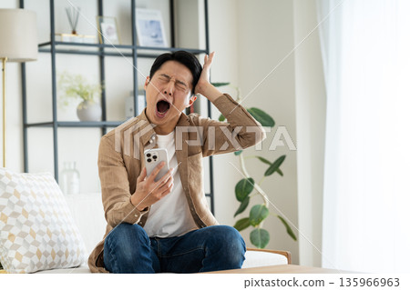 中年男子在客廳使用智能手機 中年男子在客廳使用智能手機 135966963