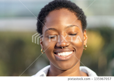 Portrait of smiling young black woman with short Portrait of smiling young black woman with short 135967057