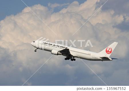 一架客機起飛上升。一架日航飛機從羽田機場起飛。 135967552