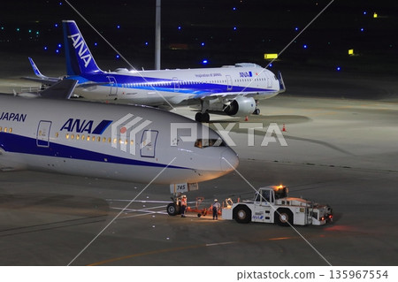 一架客機被拖走，準備執行夜間飛行任務。 135967554