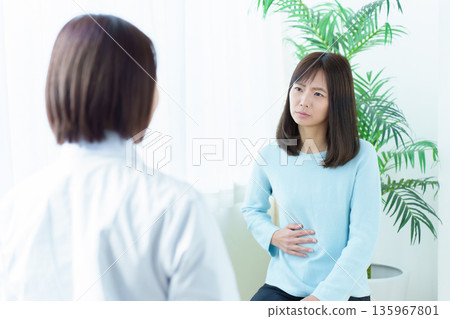 Woman receiving medical treatment at hospital, abdominal pain, feeling unwell Woman receiving medical treatment at hospital, abdominal pain, feeling unwell 135967801
