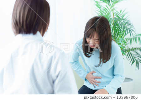 一名女子因腹痛在醫院接受治療,感覺身體不適 一名女子因腹痛在醫院接受治療,感覺身體不適 135967806