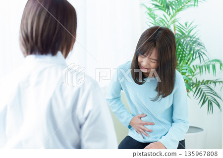 一名女子因腹痛在醫院接受治療,感覺身體不適 一名女子因腹痛在醫院接受治療,感覺身體不適 135967808