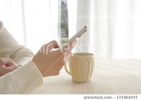 Hands of a woman operating a smartphone Hands of a woman operating a smartphone 135968935