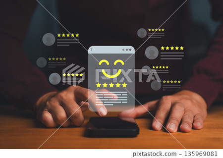 Person using smartphone with five-star rating and smiley icons, symbolizing positive customer feedback, online review, satisfaction rating, and digital reputation management for business success. 135969081