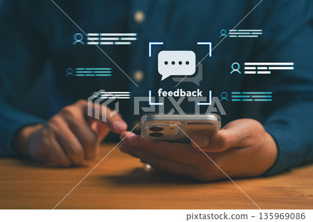 Person using smartphone with digital feedback icon, representing online review, customer communication, user experience improvement, and business reputation management in digital marketing strategy. Person using smartphone with digital feedback icon, representing online review, customer communication, user experience improvement, and business reputation management in digital marketing strategy. 135969086