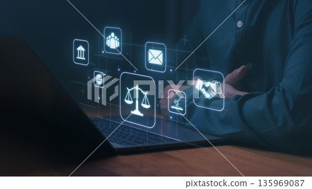 Person using a laptop with digital icons representing law, justice, communication, and business, including scales, handshake, and courthouse symbols, illustrating legal technology and digital ethics. Person using a laptop with digital icons representing law, justice, communication, and business, including scales, handshake, and courthouse symbols, illustrating legal technology and digital ethics. 135969087