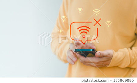 Man holding a smartphone with no Wi-Fi connection icon, symbolizing internet disconnection, network error, or poor signal, connectivity issues, technology problem, and online failure concept. Man holding a smartphone with no Wi-Fi connection icon, symbolizing internet disconnection, network error, or poor signal, connectivity issues, technology problem, and online failure concept. 135969090