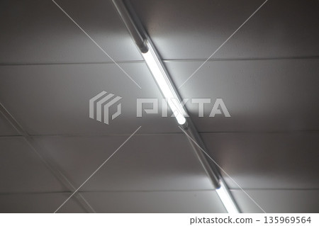 Fluorescent Light Fixture on Ceiling Illuminating Room with Even Glow for Interior Design Fluorescent Light Fixture on Ceiling Illuminating Room with Even Glow for Interior Design 135969564