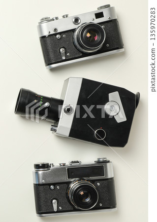 Three vintage cameras are displayed on a light surface 135970283