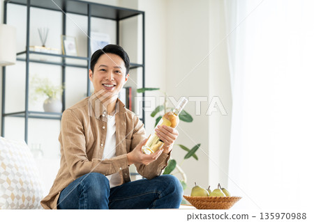 中年男子在客廳看著葡萄酒 135970988