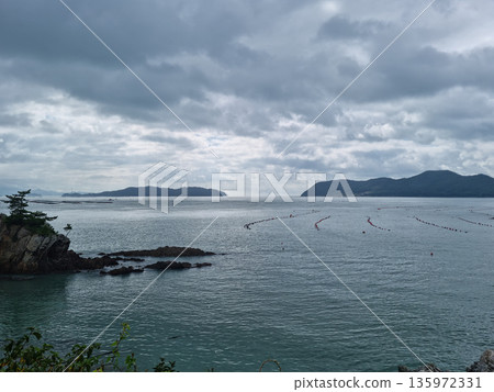 It is a seascape of Land End Village covered in dark clouds. It is a seascape of Land End Village covered in dark clouds. 135972331