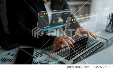 Business professional working on a laptop with digital interface displaying loading progress and analytical data in a modern office setting Gluon Business professional working on a laptop with digital interface displaying loading progress and analytical data in a modern office setting Gluon 135972528