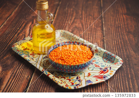 Red lentils and oil on a decorative tray 135972833