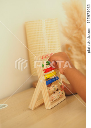 Child interacts with counting toy in a learning space Child interacts with counting toy in a learning space 135973083