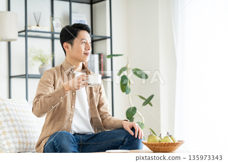 中間人在客廳裡喝咖啡 135973343