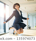 一位年輕的女上班族在辦公室裡高興地跳了起來 135974073