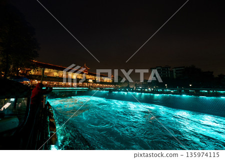 DUJIANGYAN, CHINA - JAN 24,2026: The historic Nanqiao Bridge and Dujiangyan irrigation system illuminated with vibrant blue lights at night in Sichuan province 135974115