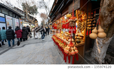 CHENGDU, CHINA - JAN 22,2026 : Traditional Chinese calabash (Hu Lu) souvenirs with red tassels displayed at a street stall in the historic Kuanzhai Alley in Sichuan province CHENGDU, CHINA - JAN 22,2026 : Traditional Chinese calabash (Hu Lu) souvenirs with red tassels displayed at a street stall in the historic Kuanzhai Alley in Sichuan province 135974120
