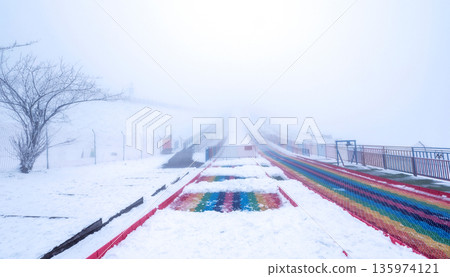 colorful rainbow slide covered in snow amidst dense white fog on Jinfo Mountain (Jinfoshan) in Nanchuan District during the winter season colorful rainbow slide covered in snow amidst dense white fog on Jinfo Mountain (Jinfoshan) in Nanchuan District during the winter season 135974121