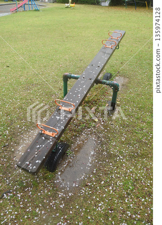 A seesaw in a park wet with spring rain 135974128