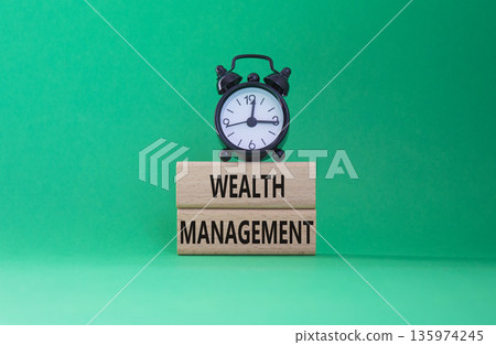Wealth Management symbol. Concept words Wealth Management on wooden blocks. Beautiful green background with alarm clock. Business and Wealth Management concept. Copy space Wealth Management symbol. Concept words Wealth Management on wooden blocks. Beautiful green background with alarm clock. Business and Wealth Management concept. Copy space 135974245