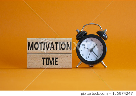 Motivation Time symbol. Concept word Motivation Time on wooden blocks. Beautiful orange background with alarm clock. Business and Motivation Time concept. Copy space 135974247
