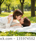 兩位年輕的日本女子躺在公園裡接吻 135974502