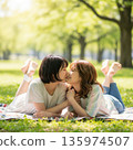 兩位年輕的日本女子躺在公園裡接吻 135974507