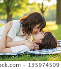 兩位年輕的日本女子躺在公園裡接吻 135974509
