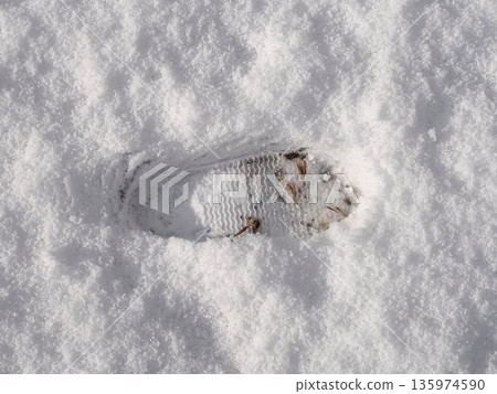 Footprints on a snowy road 135974590