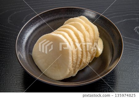 黑色背景上的未上色醃蘿蔔 135974825