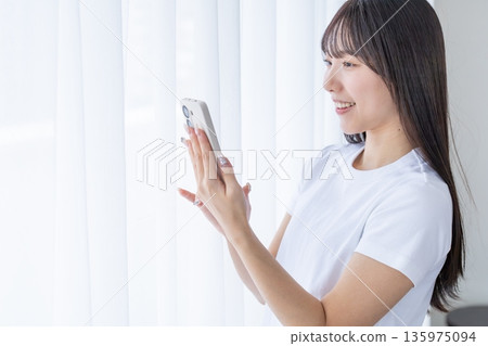 Young woman using a smartphone Young woman using a smartphone 135975094