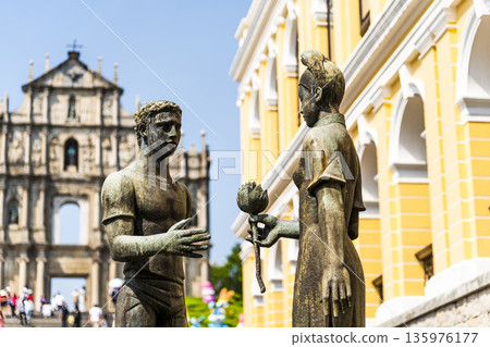 A sculpture of a young man and woman in front of the Ruins of St. Paul's at Jesus Company Square in Macau symbolizes the friendship between China and Portugal. A sculpture of a young man and woman in front of the Ruins of St. Paul's at Jesus Company Square in Macau symbolizes the friendship between China and Portugal. 135976177