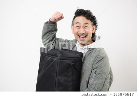 面帶微笑的送餐員手提外帶袋，準備送餐，這是送餐服務的工作畫面。 135976617