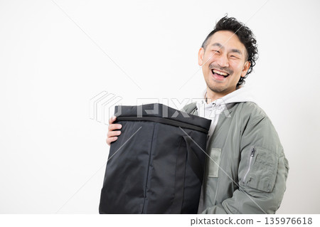 面帶微笑的送餐員手提外帶袋，準備送餐，這是送餐服務的工作畫面。 135976618