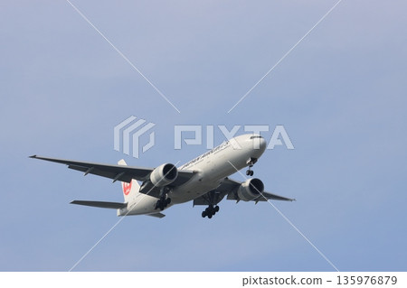 一架客機在藍天背景下降落,一架日航飛機正在進場 一架客機在藍天背景下降落,一架日航飛機正在進場 135976879