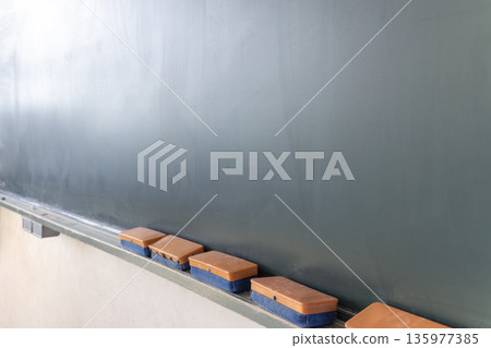 Angle view of a chalkboard eraser and chalkboard Angle view of a chalkboard eraser and chalkboard 135977385