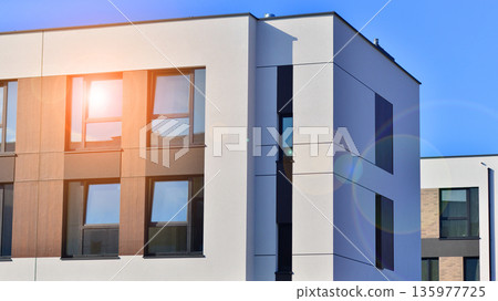 Terraced family homes in newly developed housing estate. The real estate market in the suburbs. New single family houses in a new development area. Residential homes with modern facade. 135977725