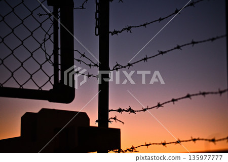 落日的天空和鐵絲網 135977777