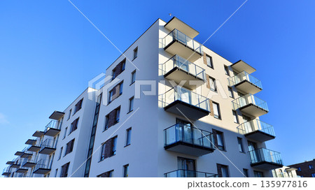Apartment residential house and home facade architecture and outdoor facilities. Blue sky on the background. Sunlight in sunrise. Apartment residential house and home facade architecture and outdoor facilities. Blue sky on the background. Sunlight in sunrise. 135977816