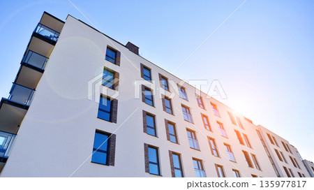 Apartment residential house and home facade architecture and outdoor facilities. Blue sky on the background. Sunlight in sunrise. Apartment residential house and home facade architecture and outdoor facilities. Blue sky on the background. Sunlight in sunrise. 135977817