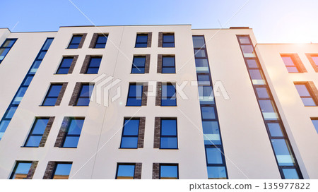 Apartment residential house and home facade architecture and outdoor facilities. Blue sky on the background. Sunlight in sunrise. Apartment residential house and home facade architecture and outdoor facilities. Blue sky on the background. Sunlight in sunrise. 135977822