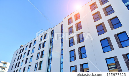 Apartment residential house and home facade architecture and outdoor facilities. Blue sky on the background. Sunlight in sunrise. Apartment residential house and home facade architecture and outdoor facilities. Blue sky on the background. Sunlight in sunrise. 135977823