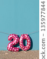 pink number 20 balloons against a vivid blue wall 135977844