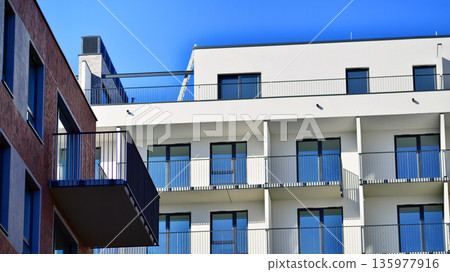 Apartment residential house and home facade architecture and outdoor facilities. Blue sky on the background. Sunlight in sunrise. Apartment residential house and home facade architecture and outdoor facilities. Blue sky on the background. Sunlight in sunrise. 135977916