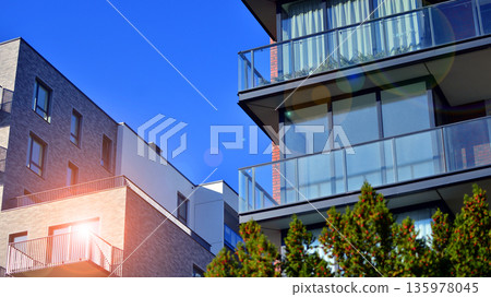 Apartment residential house and home facade architecture and outdoor facilities. Blue sky on the background. Sunlight in sunrise. 135978045